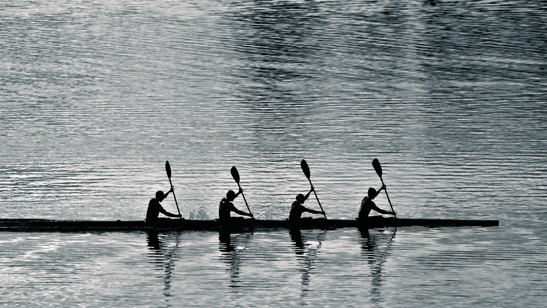Rowers in a kayak on the open water.